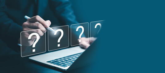 Business professional using digital pen on laptop with virtual question marks, representing problem solving, decision making, business strategy, analysis, uncertainty, innovation.