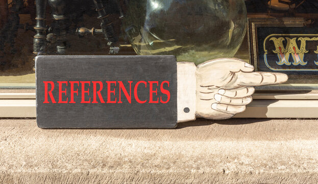 References or reference symbol. Concept word References on beautiful black wooden sign as a hand. Beautiful store front background. Business references or reference concept. Copy space.