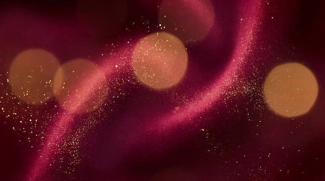 Abstract golden glitter particles streaming across a rich burgundy fabric background with soft, festive bokeh lights.