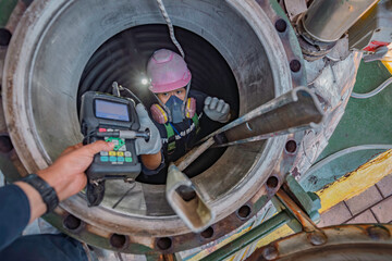 Top view male climbs up the stairs into the tank stainless chemical area confined