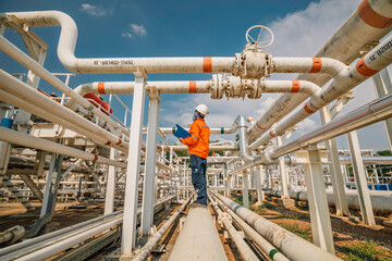 Male worker inspection at steel long pipes and pipe elbow in station oil factory during refinery valve of visual check record pipeline