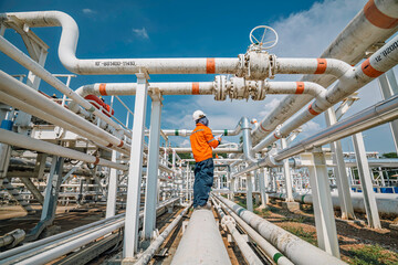 Male worker inspection at steel long pipes and pipe elbow in station oil factory during refinery valve of visual check record pipeline