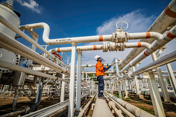 Male worker inspection at steel long pipes and pipe elbow in station oil factory during refinery valve of visual check record pipeline