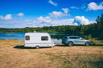 Scenic Lakeside Retreat: A Cozy Caravan and Modern Car at the Edge of Tranquil Waters