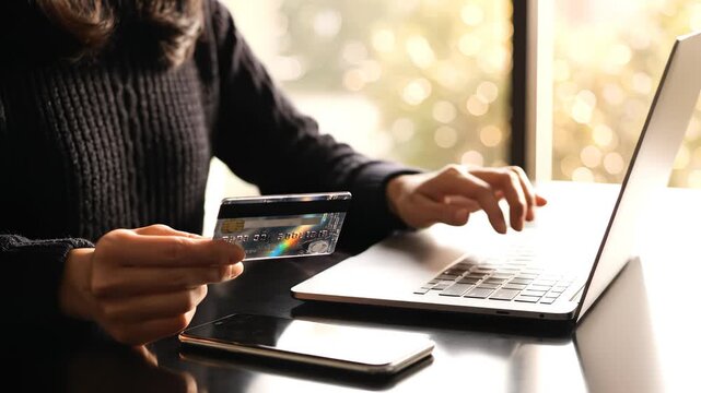 Person using credit card on laptop