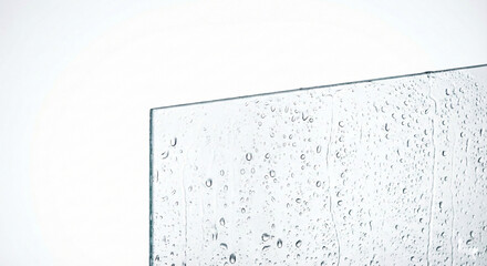 Water droplets on clear glass surface with white background