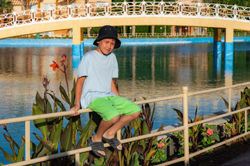 A boy on the beach in a 
 panama hat