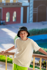 A boy on the beach in a 
 panama hat