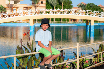 A boy on the beach in a 
 panama hat