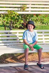 A boy on the beach in a 
 panama hat
