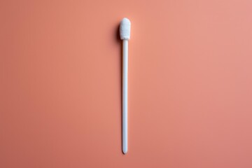 White medical swab for collecting samples on a solid peach background