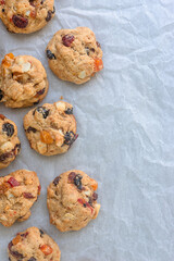freshly baked fruitcake cookies on baking paper background.