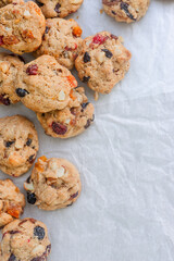 freshly baked fruitcake cookies on baking paper background.