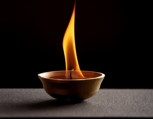 a single flame burning in a small bowl