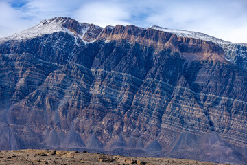 Snow covered mountains and the rocky arctic landscape and tundra of Geologfjord, Northeast Greenland National Park. Known for the colourful rock strata.