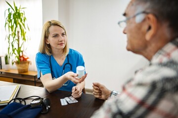 Nurse providing medication to elderly patient in clinic