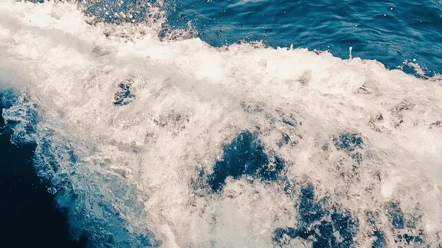 Olas rompiendo junto a una embarcaci&oacute;n en movimiento sobre el mar