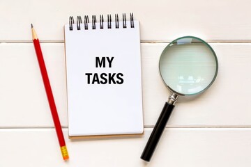MY TASKS text on notebook on a white wooden background , business concept.