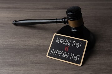 Judge gavel with a sign showing revocable trust versus irrevocable trust. Legal planning, estate law, and financial decision concept.