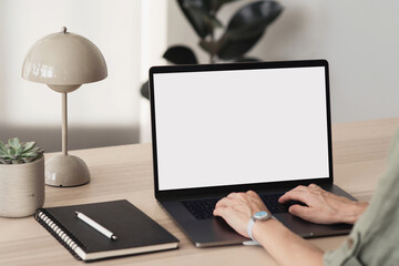 Young woman using laptop with blank empty mockup screen, female hands typing on computer keyboard closeup. Working or studying from home office, freelance, online learning, distance education concept
