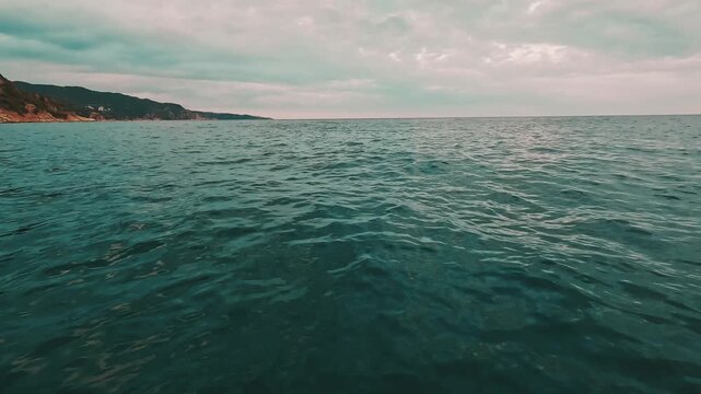 Aguas tranquilas en una cala de la Costa Brava vistas desde un velero fondeado en 4K