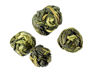 Rolled green tea pearls made from dried tea leaves in a scattered composition, premium loose tea ingredient cutout on isolated background
