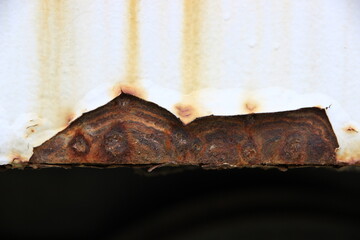 The iron background is old, dirty, and heavily rusted.