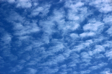 A bright blue sky background with beautiful clouds; a bottom-down, wide-angle view.