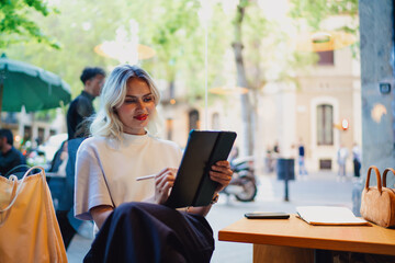 Woman using stylus on tablet outdoors in daylight © BullRun