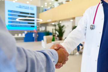 Health professional greets patient in modern clinic lobby during consultation visit