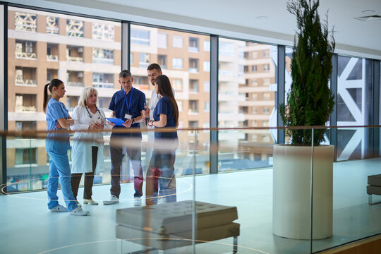Team of healthcare professionals discussing patient care in a modern hospital setting during the daytime