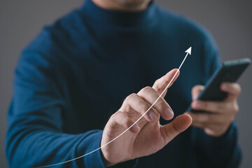 Business person touching rising arrow graph while using smartphone. Concept of business growth, financial success, performance improvement, digital analytics, investment strategy, and future progress.