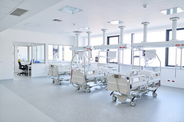 Fototapeta premium Modern hospital room with multiple empty beds and bright windows in a healthcare setting