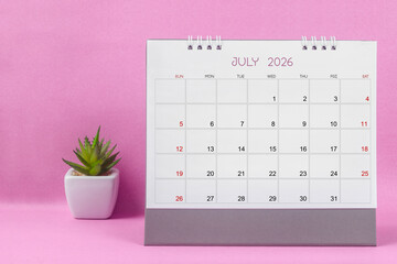 July 2026 desk calendar for year 2026 on pink background.