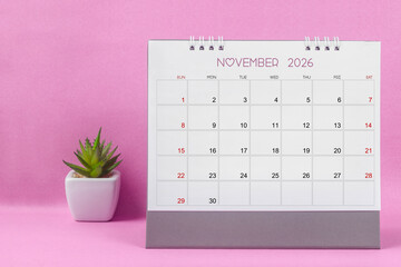 November 2026 desk calendar for year 2026 on pink background.