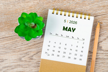 May 2026 monthly desk calendar and pencil with plant pot decoration.