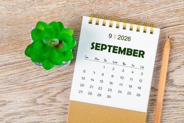 September 2026 monthly desk calendar and pencil with plant pot decoration.