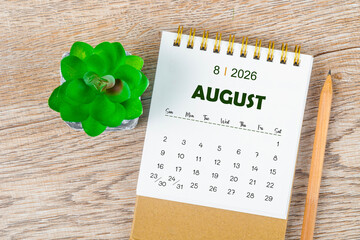 August 2026 monthly desk calendar and pencil with plant pot decoration.