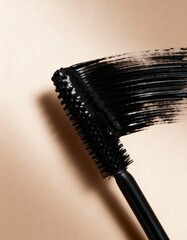 black mascara swatch with applicator on the beige background, black paint, brush strokes, cosmetics textures, mascara, eyebrow mascara