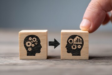 A person's hand placing wooden blocks with a head symbol, representing the process of knowledge transfer and skill exchange