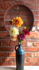 Flowers in a two-toned vase in front of a brick wall with a circle cut out on the wall