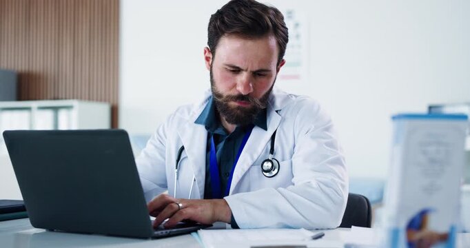 Man, doctor and typing with laptop in office for research, medical report and compliance form. Male person, pc and documents for Telehealth, healthcare schedule and information for treatment planning