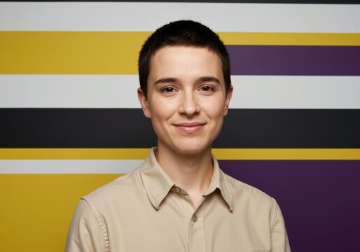 Nonbinary person smiling and standing close up with prideflag background demonstrating diverse identity and nonconforming gender expression for inclusivity concept