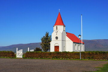 Beautiful Glaumb&aelig;r Lutheran church or Glaumb&aelig;jarkirkja, in the Varmahl&iacute;&eth;, Skagafj&ouml;r&eth;ur, Northern Iceland. Traditional Icelandic building with red roof, white wooden gate and turf fence, close up.