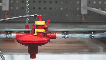  gas valve.  valve is attached to a pipe and is surrounded by other pipes.  valve is in the middle of image and is the main focus