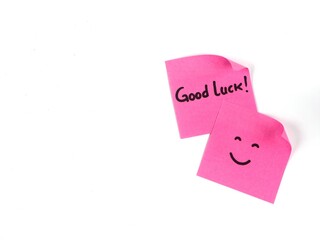 Good luck message hand written on pink paper on white background. positive vibes, motivation, and support concept. Copy space 