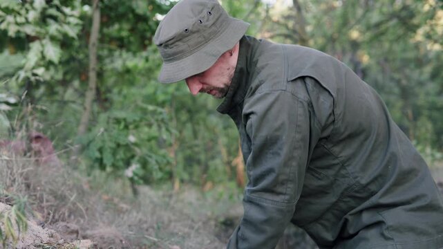 An engineering soldier digs a trench with a shovel to protect himself from enemy attack. The theme is war and training centers.