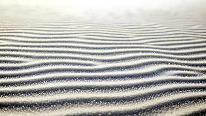 Serene sand dune pattern with wavy ridges and soft light shining on the textured surface creating a calming scene