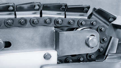 Food packaging machine with conveyor belt driven by chain, industrial concept background.