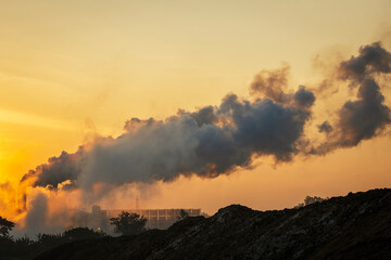 Smoke emissions from chimneys and industrial waste contributing to air pollution at sunrise, which pollutes environment and destroys the ecosystem, industry in Asia.